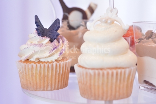 Muffin with whipped cream and glitter purple. Purple marzipan butterfly