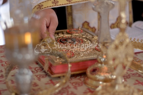 Orthodox priest holding the crowns in front of groom and bride