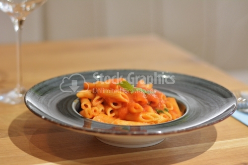 Penne pasta with red sauce and basil.