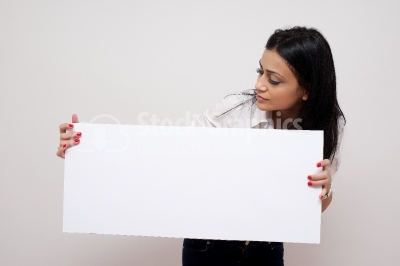 Pretty brunette woman posing behind a white panel isolated on wh