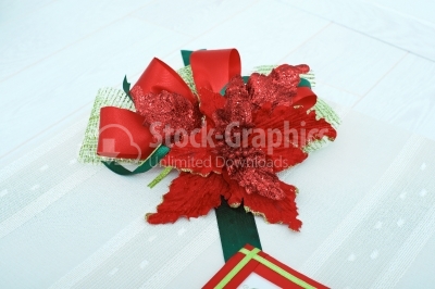 Red artificial flower on top of a hand made gift box