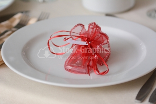 Red gift with bow on a white plate