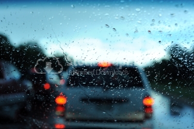 Road view through car window with rain drops
