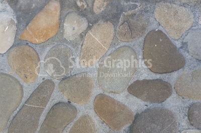 Round rocks on cement wall