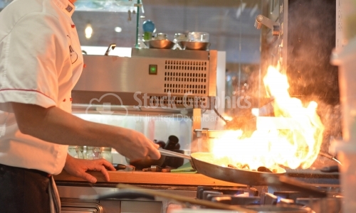 Seafood cooked with flame. The chef is photographed from the side.