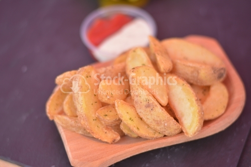 Spicy wedges potato on a wooden dish