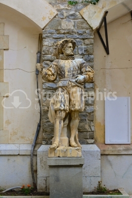 Statue in front of beautiful Peles castle and ornamental garden 