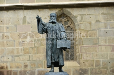 Statue with a men holding an open book and pointing to his right