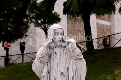 Street artist playing disguised as a white statue