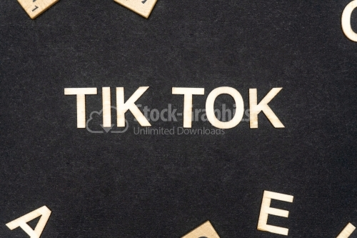 TIK TOK word written on dark paper background. TIK TOK text for your concepts