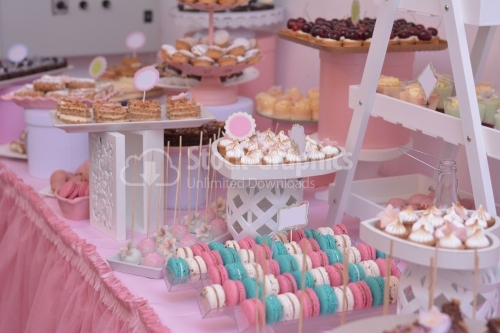 Trays with macarons and meringue, in a pink decor. Candy bar