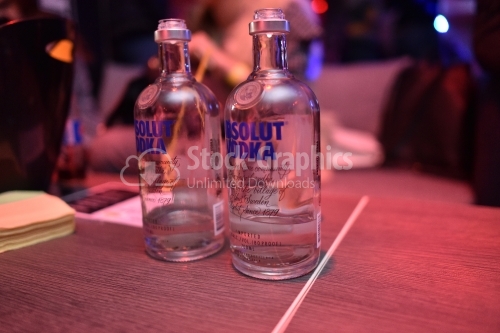 Two almost empty vodka bottles on the wooden table
