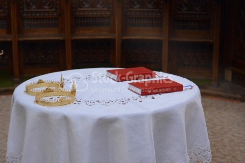Two ceremonial crowns and two holy bibles as orthodox wedding accessories