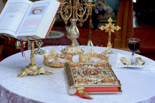 Two crowns for a orthodox wedding ceremony , the bible and a glass of red wine