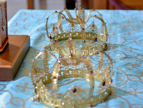 Two golden crown with gemstones on red napkin on altar in church. Traditional wedding ceremony. Religion