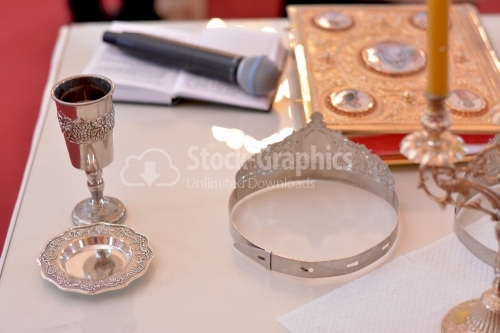 Two silver crowns for a orthodox wedding ceremony , the bible and a silver chalice of red wine