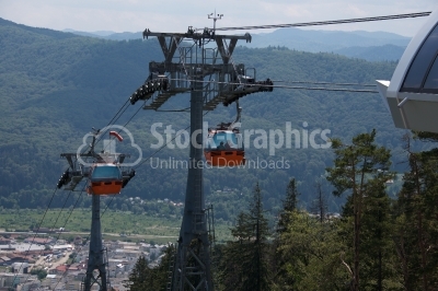 Urban cable car running across the forest and city