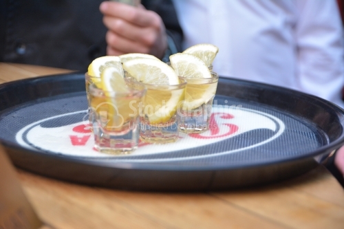 Vodka in shot glasses with lemon on the tray