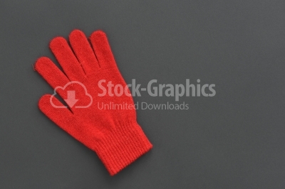 Warm woolen knitted glove on dark texture