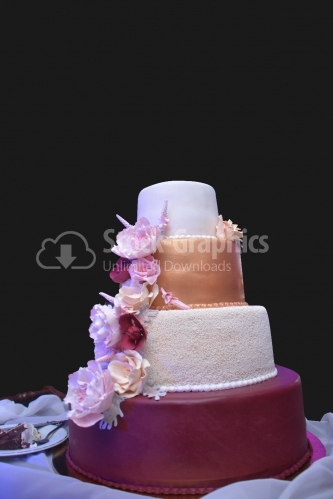 Wedding cake decorated with white pearls and flowers and gold an