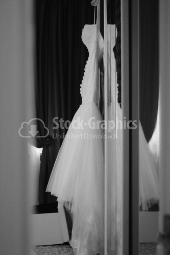 Wedding dress hanging from furniture. Black and white photography.