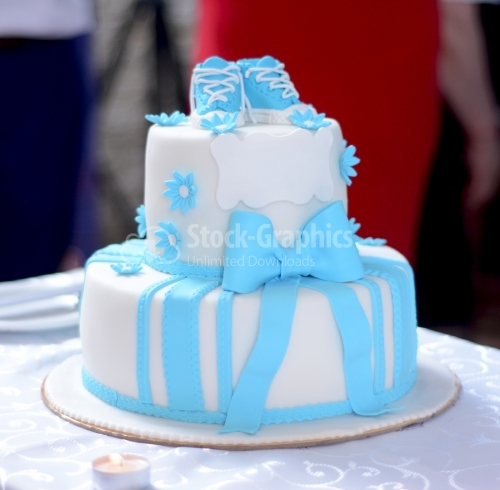 White cake with blue bottom and blue sneakers on top