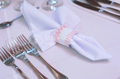 White towel with pink details placed on a wedding table