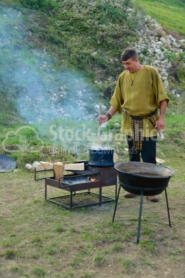 Woman cooking on campfire