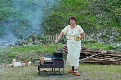 Woman making food on a big cauldron