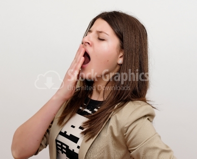 Yawning tired woman. Beautiful caucasian model isolated on white