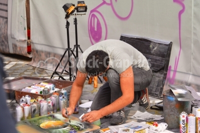 Young artist working on the street creating spray paint art.