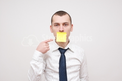 Young businessman pointing at his mouth