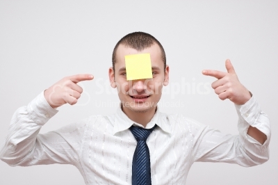 Young happy guy with post it on his forehead - Stock Image