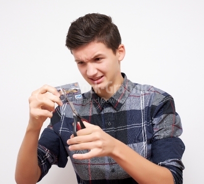 Young man cutting credit card 