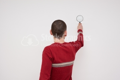 Young man look through magnifying glass 